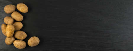 Potatoes Boiled in Their Skins on Dark Stone Background with Place for Text. Cooked Whole Vegetables Top Viewの写真素材