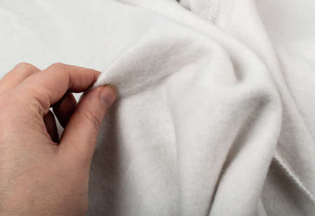 Hand on Soft gray cotton, elastane and polyester fabric texture background. Warm cozy clothing for home and gym in a sporty styleの写真素材