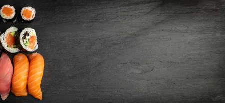 Japanese Sushi Set Mockup on Dark Sate Plate Top View. Nigiri and Nori Maki Sushi Rolls with Copy Spaceの写真素材