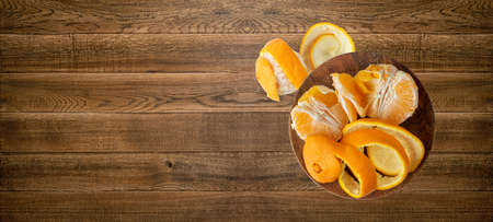 Fresh Orange and Peel on Wood Desk Background. Zest and Peeled Orange Mockup on Wooden Table with Copy Space Top Viewの写真素材