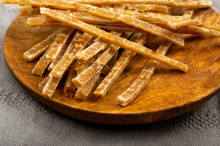 Macro shot of dried fish sticks. Dry salted seafood snack, hake stockfish, small pieces of...