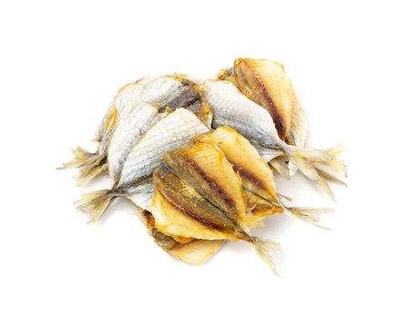 Dry salted yellowstripe scad. Dried small fish isolated, selaroides snack, stockfish beer snacks, dried flat fillet on white background top viewの写真素材
