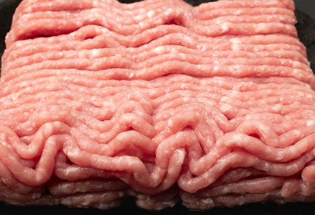 Pork mince meat texture background. Ground fresh pig fillet textured pattern, uncooked pork...