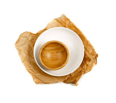 Empty wood bowl isolated on white background top view. Rustical kitchen mock up with tree cut and craft paperの写真素材