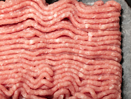 Pork mince meat texture background. Ground fresh pig fillet textured pattern, uncooked pork...