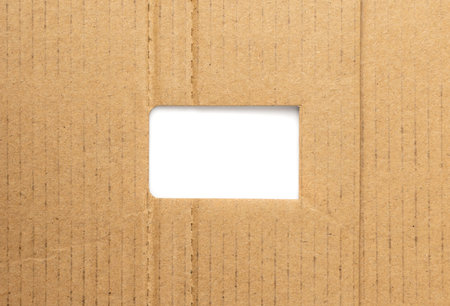 Cardboard hole background. Carton torn with copy space, kraft paper frame top view