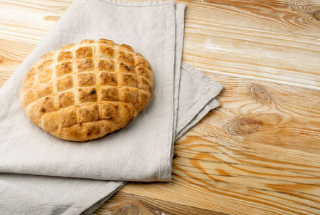 Focaccia bread on rustic background. Homemade round ciabatta, rustic thick flatbread, traditional wheat loaf bun, circle flat bread on gray napkinの写真素材