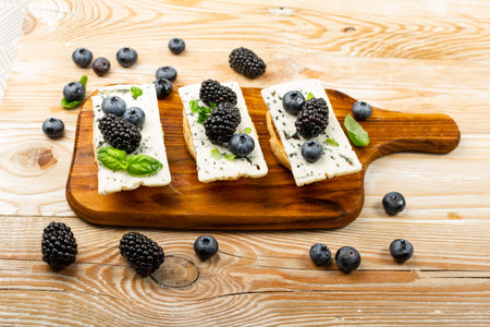 Blue cheese on bread. Gorgonzola with berries and honey, bruschetta with ricotta, blueberries and...