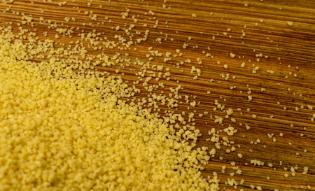 Couscous texture background top view. Dry cuscus pattern, raw kuskus wallpaper, uncooked cous cous or semolina granules scattered on wooden rustic background with copy spaceの写真素材
