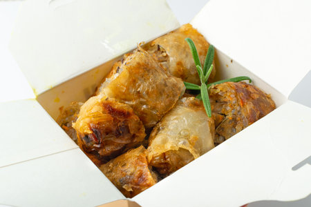 Spring rolls isolated. Rollos primavera, fried rollito, arrollado, lumpia cuts, popiah, nem, sajgonki or fried dim sim in paper container on white backgroundの写真素材
