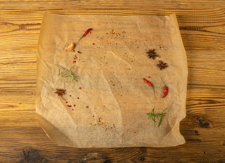 Brown Baking Paper with Herbs and Spices, Kraft Cooking Paper Sheet on Wooden Texture Background, Bakery Parchment Mockup, Greaseproof Baking Paper Top Viewの写真素材
