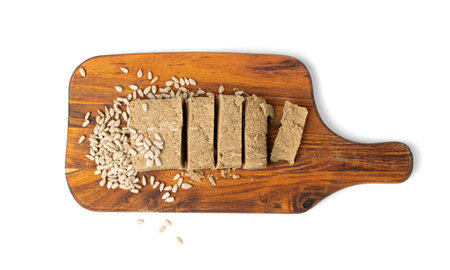 Halva Pieces on Wooden Cutting Board Isolated, Sunflower Halawa, Halvah or Halwa on White Background...
