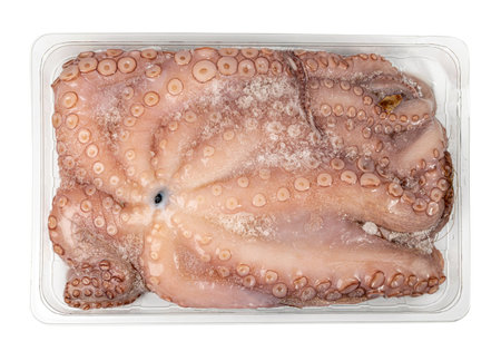 Whole frozen octopus in plastic package isolated on white background. Raw iced seafood with squid big tentacles top viewの写真素材