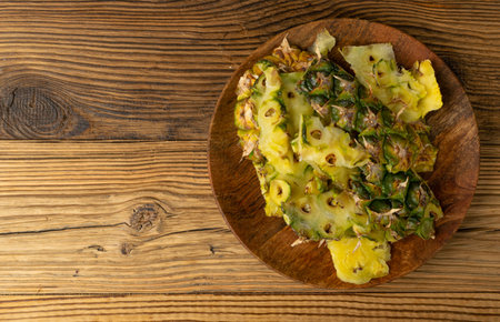 Pineapple Skin, Bio Garbage, Vegetable Waste, Pineapple Peel, Fruit Peeling Waste Pile, Organic Compost Ingredient on Wood Background Top Viewの写真素材