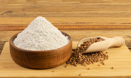 Buckwheat Flour Pile in Wood Bowl, Dry Buck Wheat Powder, Buckwheat Gluten Free Flour on Wooden Rustic Background Side Viewの写真素材