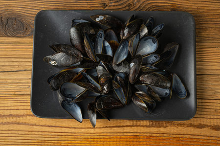 Empty Mussels Shell, Black Clams Shells, Eaten Mollusc, Empty Shellfishes, Seafood Leftovers Mussel on Wood Background Top Viewの写真素材