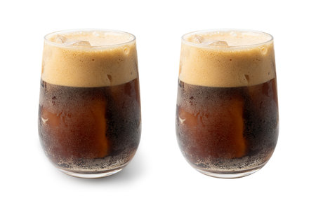 Iced Porter Beer Isolated, Cold Stout in Glass, Dark Beer with Foam and Ice Cubes, Bubbles on...