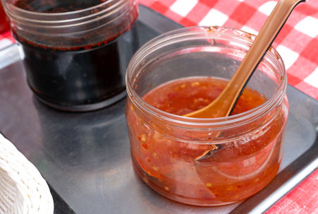 Sweet Chili Sauce, Red Asian Dip, Hot Thai Sauce with Spices and Sugar, Sweet Chinese Chili Sauce in a Street Restaurantの写真素材
