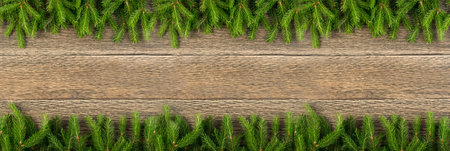 Christmas background with fir branches on wooden backdrop flat lay and top view. Yuletide floral...