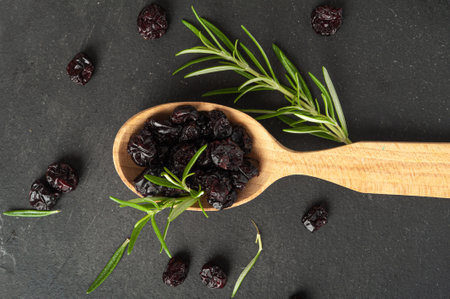Dry Cranberry Pile, Dried Lingonberry Berries in Wood Spoon, Cowberry Natural Dessert, Healthy Diet, Organic Snack, Dry Cranberries on Black Background Top Viewの写真素材