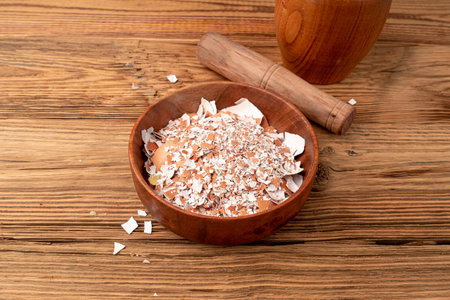 Broken Egg Shell in Bowl, Crushed Eggshell, Calcium Supplement, Cracked Eggshells, Natural Compost Ingredient, Broken Egg Shells on Wood Background Top Viewの写真素材