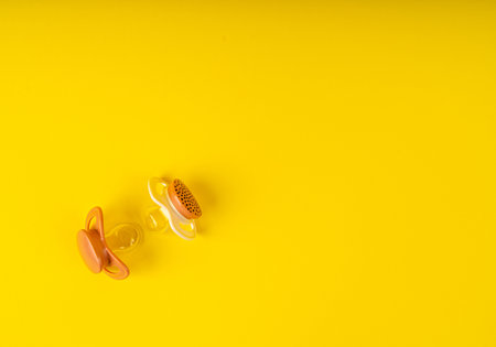 Pacifier Isolated, Orthodontic Baby Dummy, Rubber Pastel Kid Soother, New Healthy Silicone Orthodontic Pacifier on Yellow Backgroundの写真素材