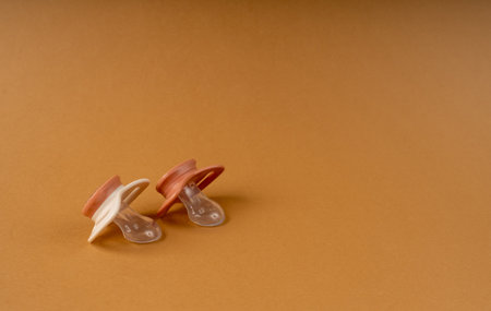 Pacifier Isolated, Orthodontic Baby Dummy, Rubber Pastel Kid Soother, New Healthy Silicone Orthodontic Pacifier on Brown Backgroundの写真素材