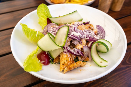 Caesar Salad Closeup, Grilled Chicken Salat with Parmesan Cheese, Greens, Dressing and Cucumbers, Caesar Salad on White Restaurant Plateの写真素材