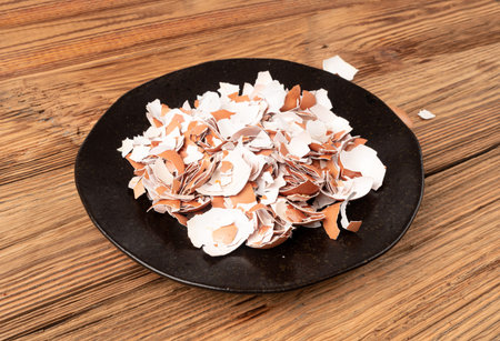 Broken Egg Shell in Bowl, Crushed Eggshell, Calcium Supplement, Cracked Eggshells, Natural Compost Ingredient, Broken Egg Shells on Wood Table Background Top Viewの写真素材