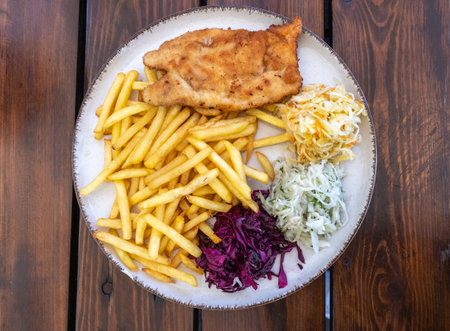 Traditional Polish Chop, Breaded Cutlet, Roasted Pork Steak in Breadcrumbs with Fresh Cabbage Salads and Potatoes, Cutlet Schabowy on White Restaurant Plateの写真素材