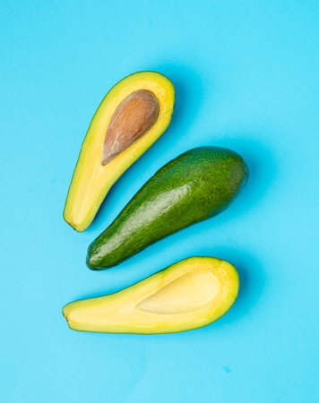 Avocado Isolated, Whole Avokado, Green Avocados Slice, Fresh Alligator Pear, Guacamole Ingredient, Long Avocado Fruit on Blue Background Top Viewの写真素材