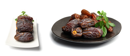 Big dates isolated. Dry date fruits heap, medjool, medjoul or majhool, royal dates with green leaves on white backgroundの写真素材