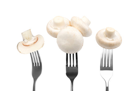 White champignons on forks isolated on white background. Fresh mushrooms eatingの写真素材