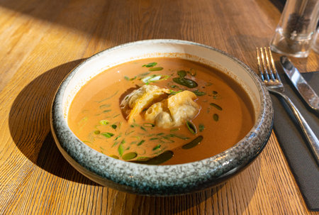 Nepalese Momo Jhol Achar Dumpling Soup, Fried Gyoza Broth, Spicy Tomato Momo Seasoned Soup in Exquisite Serving Restaurant Bowl in Sunlight Closeupの写真素材