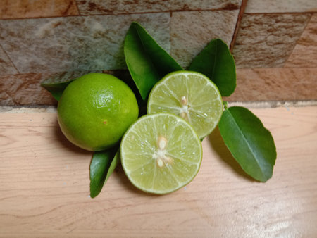 Lemon green fresh and two halves slice  on cement flooring background closeup.