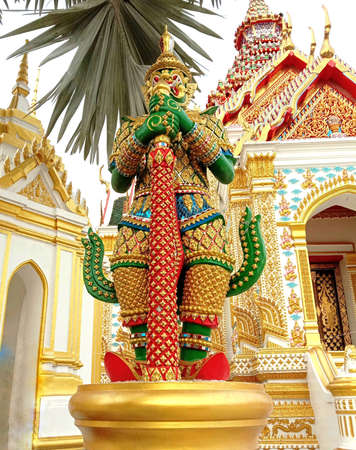 Church of Buddhist temple with the giant is standing in front isolated on blue sky background closeup. Is a place religious ceremonies for Thailand culture people.のeditorial素材
