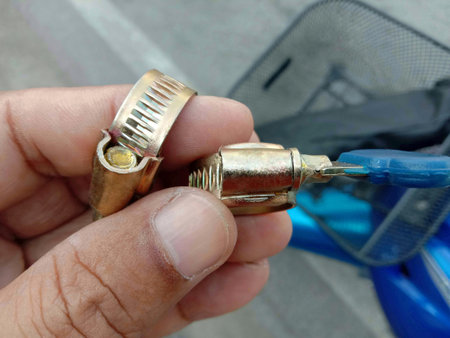 Metal hose clamps in hand on blurred background closeup.