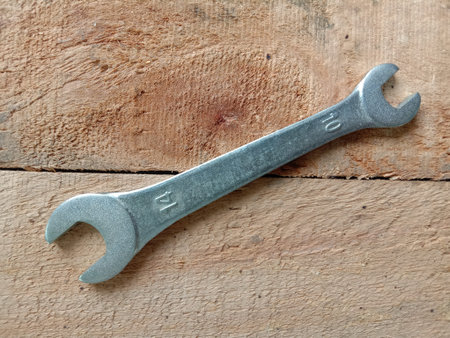 Open-end wrench hardware tools, top view isolated on wooden flooring background closeup.の写真素材