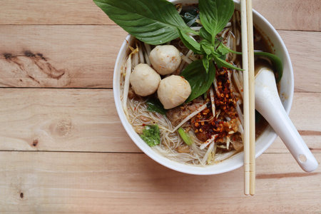 Beef noodles, vegetables with spoon and chopsticks in the bowl, Thai delicious food isolated on...