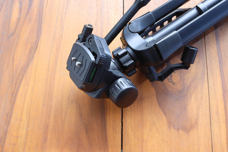 Head of the camera tripod, clipping part isolated on wooden background closeup