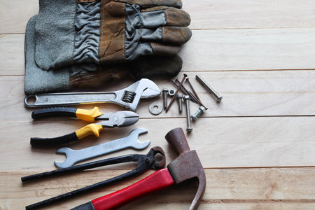 Variety of work tools on wooden background. Top view with copy space.