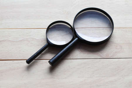 Magnifying glass on wooden background. Top view with copy space.の写真素材