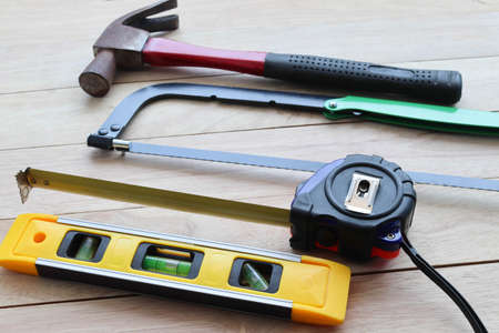 Hammer, tape measure and nails on wooden background. Construction tools.の写真素材
