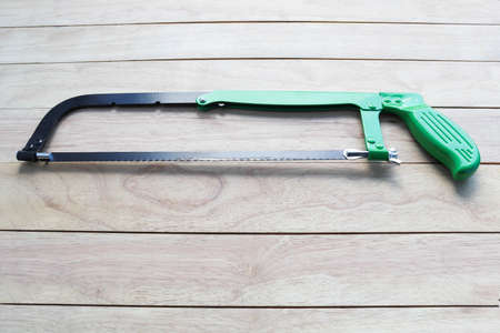 Hacksaw on a wooden background. Copy space for text.の写真素材