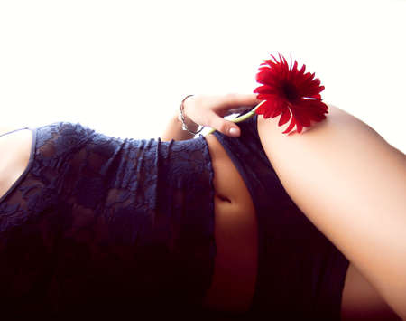 beautiful part of a girl body lying on one side with red gerberの写真素材