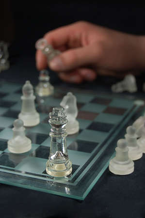 Set of glass chess, hand holding figureの写真素材