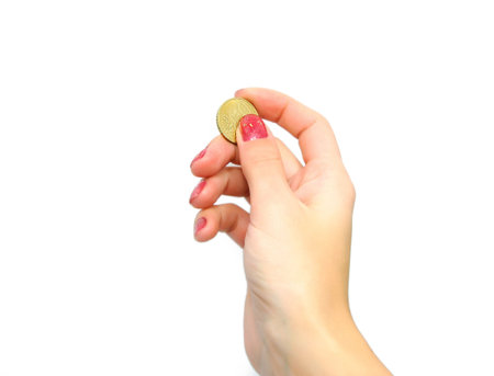 Female hand holding coin isolated on whiteの写真素材