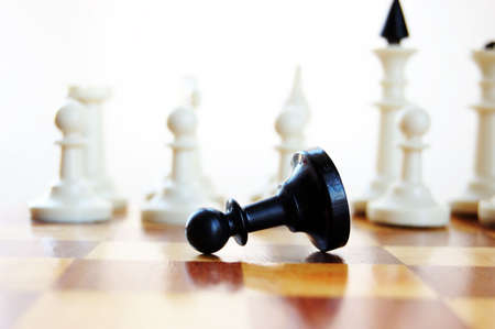 Black pawn lying on chess boardの写真素材