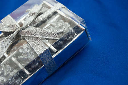 silver gift box on blue satin fabricの写真素材