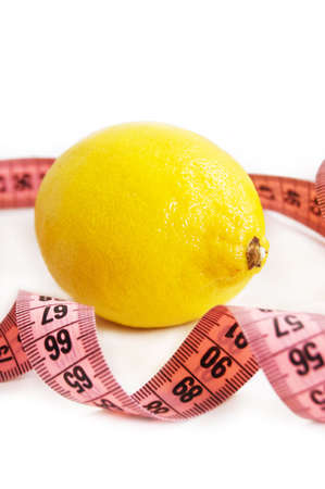 lime with measure tape over whiteの写真素材